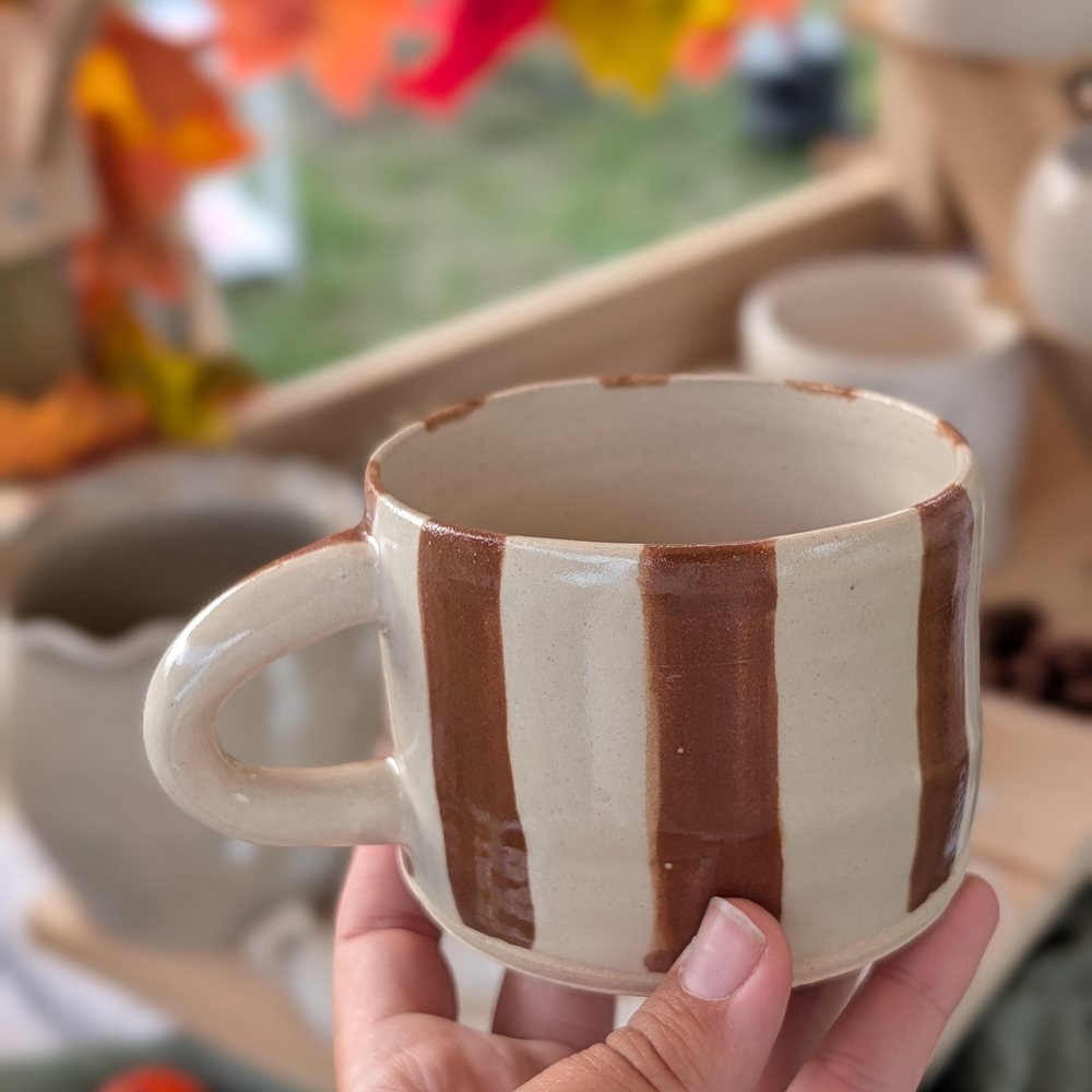 Cream mug with hand-painted brown stripes and a pale handle