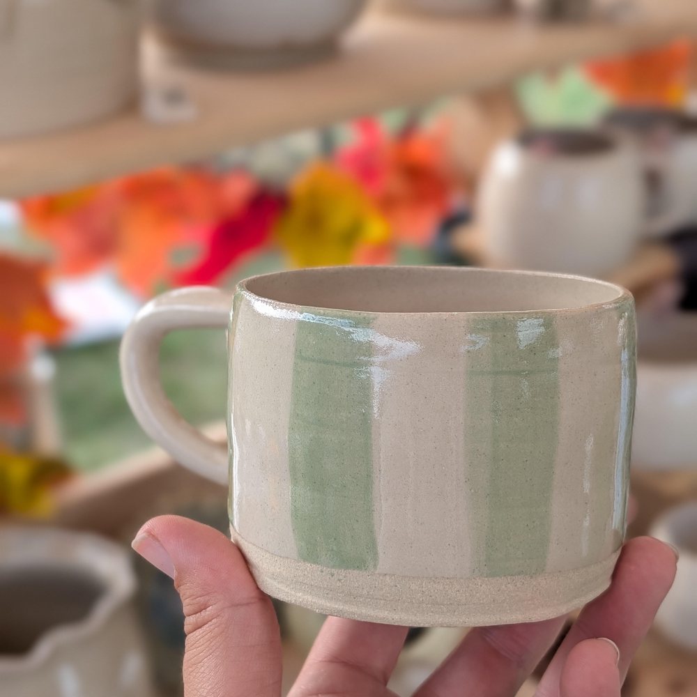 Cream mug with hand-painted soft green stripes