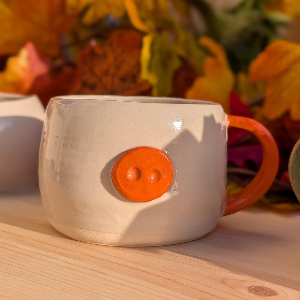 Handled mug with an orange button snout and matching handle