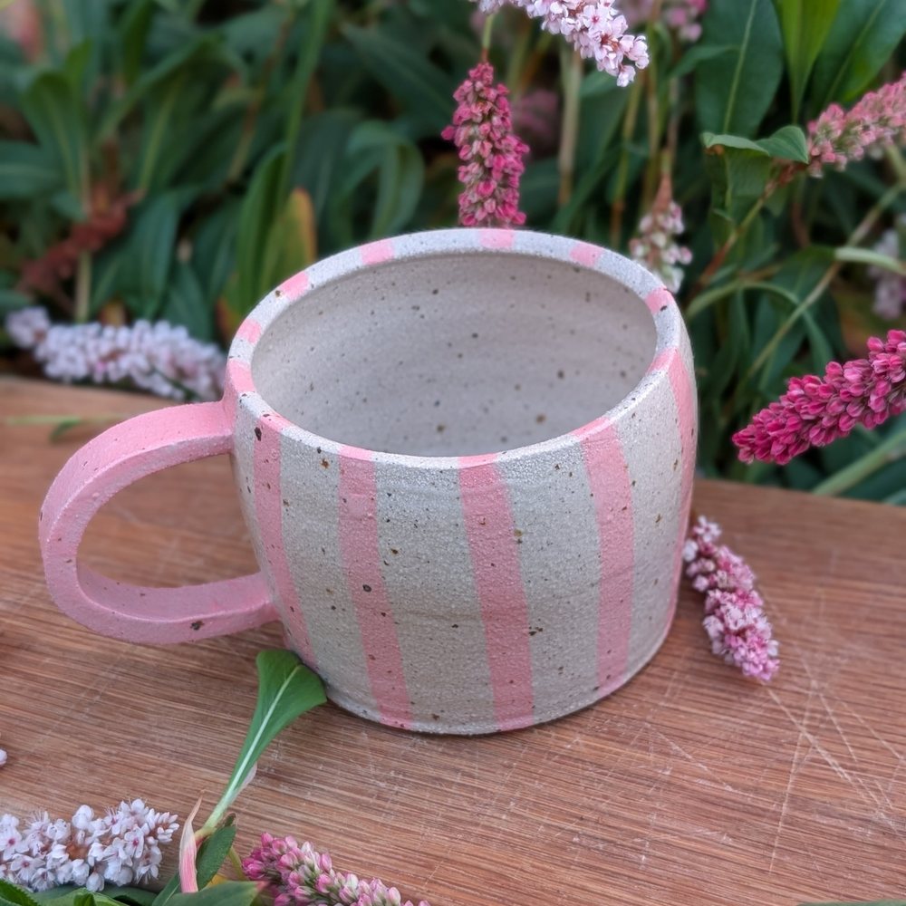 Speckled clay mug with hand-painted pink stripes and a pink handle
